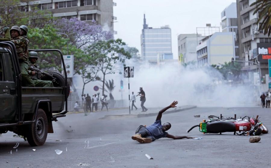 A supporter of Kenyan opposition National Super Alliance (NASA) coalition, lies on the ground after a police truck hit his motorbike during a protest along a street in Nairobi, Kenya. Kenya,Kenya election,kenya election 2017,Kenya election canceled,Police clash