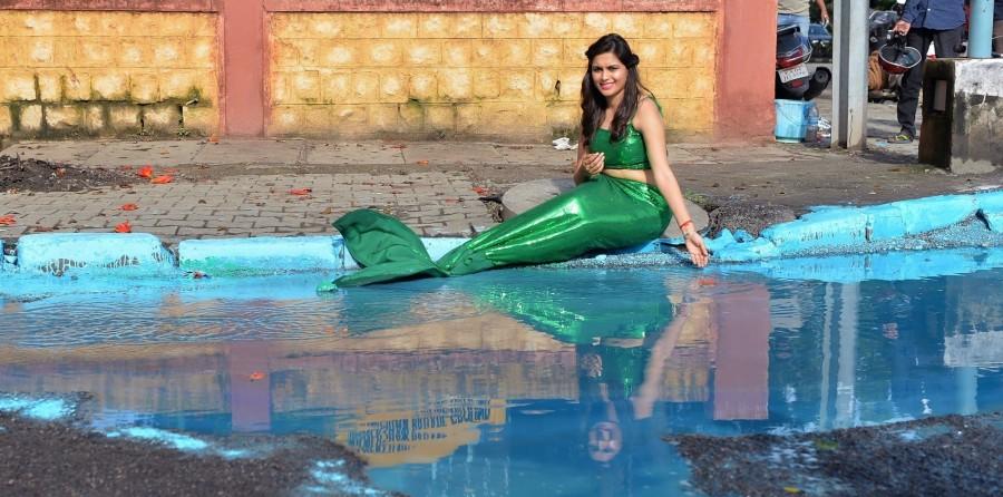 Sonu Gowda poses as a mermaid in front of a pothole where artist Baadal Nanjundaswamy created an art work on Cubbon Road in Bengaluru. Sonu Gowda,actress Sonu Gowda,pothole,bangalore pothole,Bangalore rain,Sonu Gowda poses near pothole