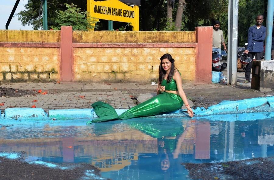 Actress Sonu Gowda poses as a mermaid in front of a pothole where artist Baadal Nanjundaswamy created an art work on Cubbon Road in Bengaluru, on Oct 13, 2017. Sonu Gowda,actress Sonu Gowda,pothole,bangalore pothole,Bangalore rain,Sonu Gowda poses near pothole