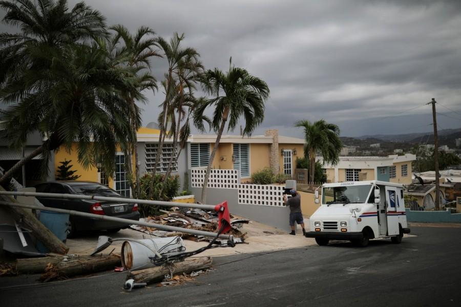 Alfredo Martinez, a mail man for the U.S. Postal Service delivers the mail at an area damaged by Hurricane Maria in San Juan. Only 15 percent of electrical power has been restored since the storm bludgeoned the U.S. territory on Sept. 20, but 99 of Puerto Rico’s 128 post offices are delivering mail. Tents have taken the place of post offices wrecked by Maria. Puerto Rico,Hurricane Maria,U.S. Postal Service