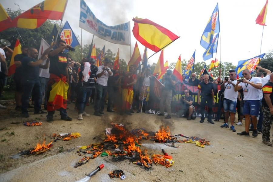 Ultra right-wing demonstrators burn "Esteladas" (Catalan separatist flags) during Spain's National Day in Barcelona. Spain celebrates National Day,National Day,Spain National Day