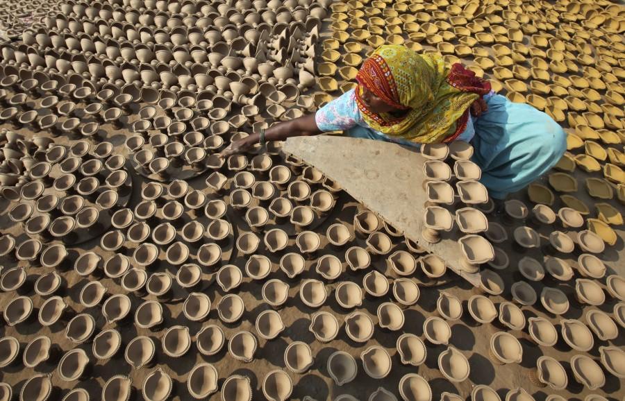 A woman puts out earthen lamps to dry in the sun at her workshop ahead of the Hindu festival of Diwali in the northern Indian city of Chandigarh. Diwali 2017,Happy Diwali 2017,Happy Diwali,festival of light,significance of festival of lights,People gears for festival of light,People gears for Diwali,People gears for Diwali 2017,happy diwali,Diwali quotes,Diwali wishes,Diwali greetings
