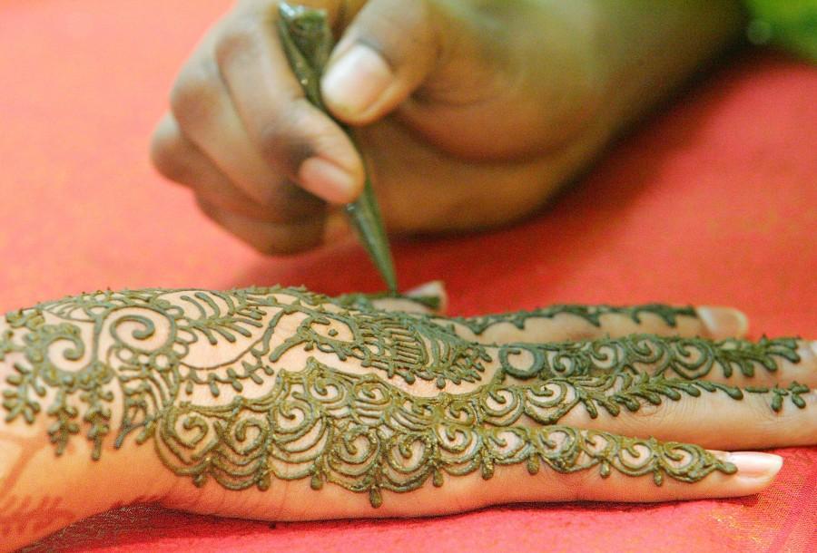 A Malaysian Hindu paints her hand with "mehendi" or henna in Kuala Lumpur. Diwali 2017,Happy Diwali 2017,Happy Diwali,festival of light,significance of festival of lights,People gears for festival of light,People gears for Diwali,People gears for Diwali 2017,happy diwali,Diwali quotes,Diwali wishes,Diwali greetings