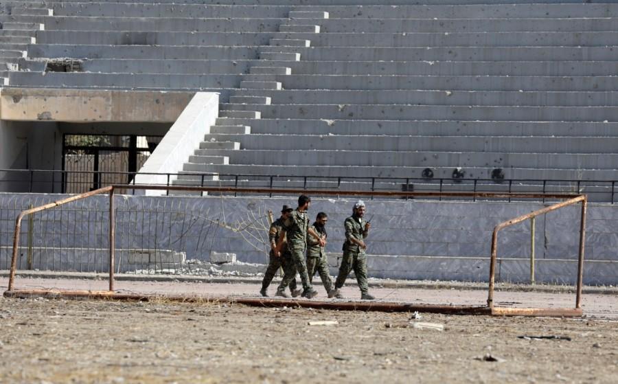 Fighters of Syrian Democratic Forces walk at the stadium in Raqqa, Syria October 18, 2017. Islamic State bunker,Islamic State,Raqqa,Syrian Democratic Forces,Syrian Democratic Forces (SDF),Islamic State militants
