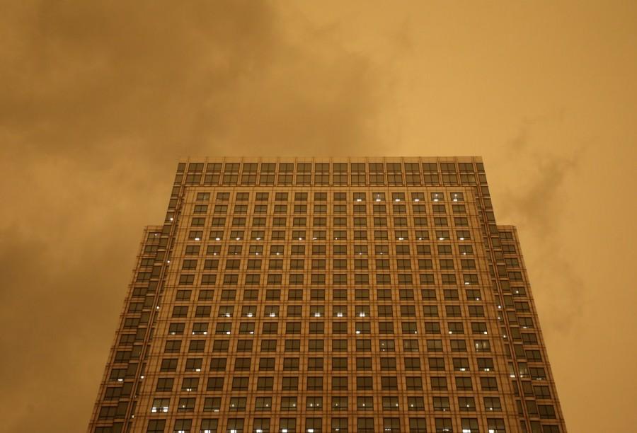 The sky turns red over buildings in Canary Wharf as dust from the Sahara carried by storm Ophelia filters sunlight over London. Ophelia turns London sky red,London sky red,London sky,Ophelia filters sunlight