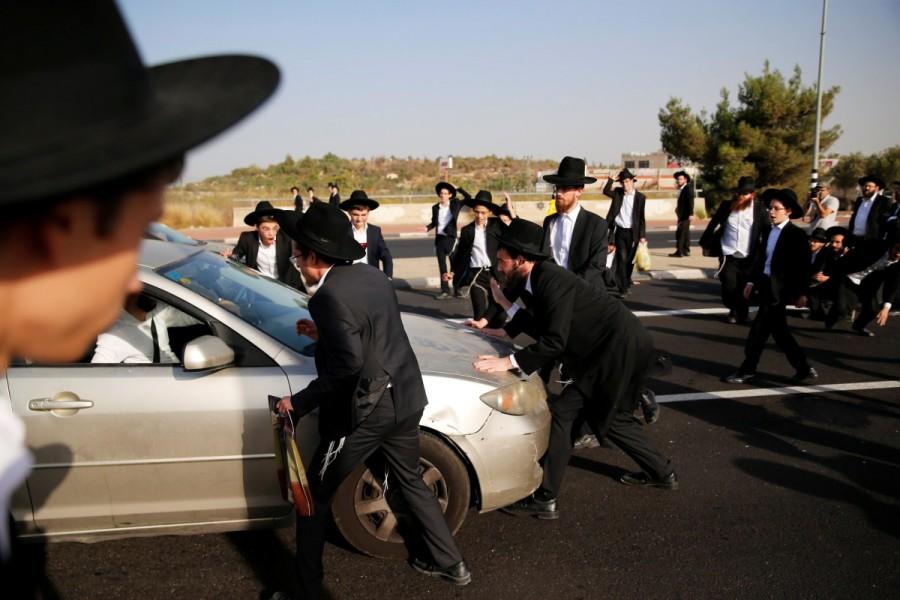 Ultra-Orthodox Jewish men surround a car as they try to block a road during a protest against the detention of members of their community who failed to report to a military recruiting office, near Modiin. Ultra-Orthodox protest,Ultra-Orthodox,Ultra-Orthodox protest against the detention,military recruiting office
