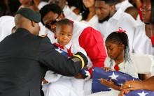 La David Johnson Jr. son of U.S. Army Sergeant La David Johnson, is presented with an American flag.