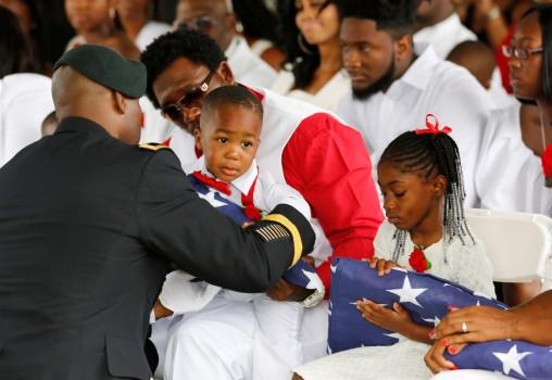 La David Johnson Jr. son of U.S. Army Sergeant La David Johnson, is presented with an American flag.