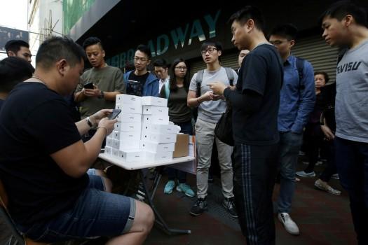 A man pays to buy new iPhone Xs from those who just bought at Apple Stores, on a street in Hong Kong, China November 3, 2017.