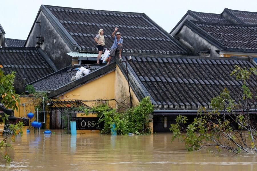 People stand on the roof of their house in Hoi An. Vietnam,Vietnam after typhoon,Deadly flooding in Vietnam,Deadly flooding,Typhoon Damrey