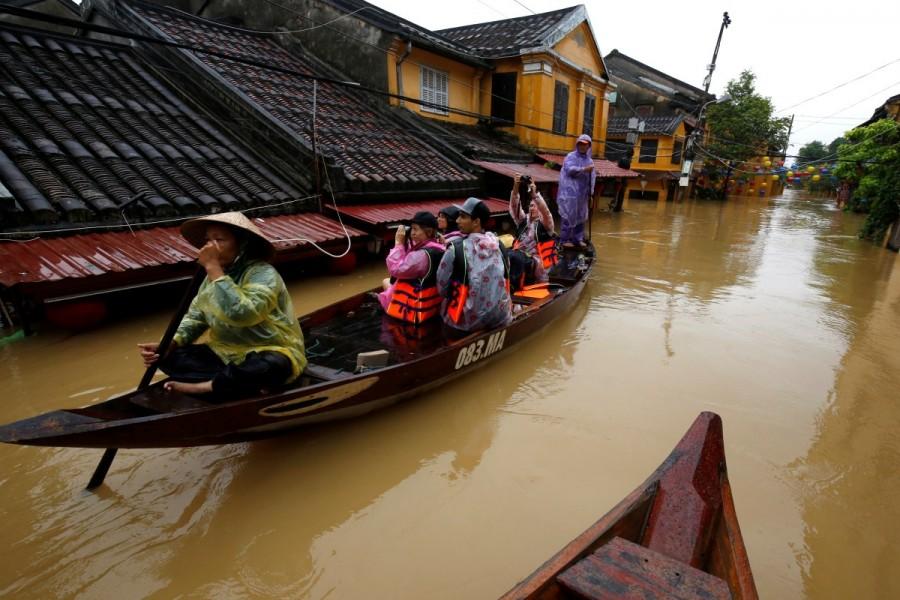 People ride a boat along submerged houses in Hoi An. Vietnam,Vietnam after typhoon,Deadly flooding in Vietnam,Deadly flooding,Typhoon Damrey