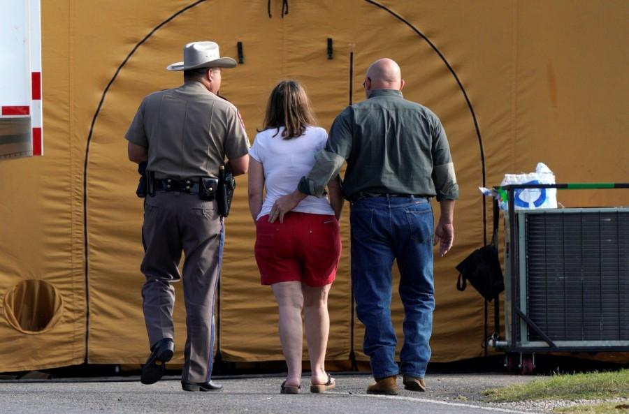 A woman is escorted to site of a shooting at the First Baptist Church of Sutherland Springs, Texas, U.S. November 6, 2017. Mass shooting,Texas church,First Baptist Church,Texas church gunman Devin Kelley,Devin Kelley