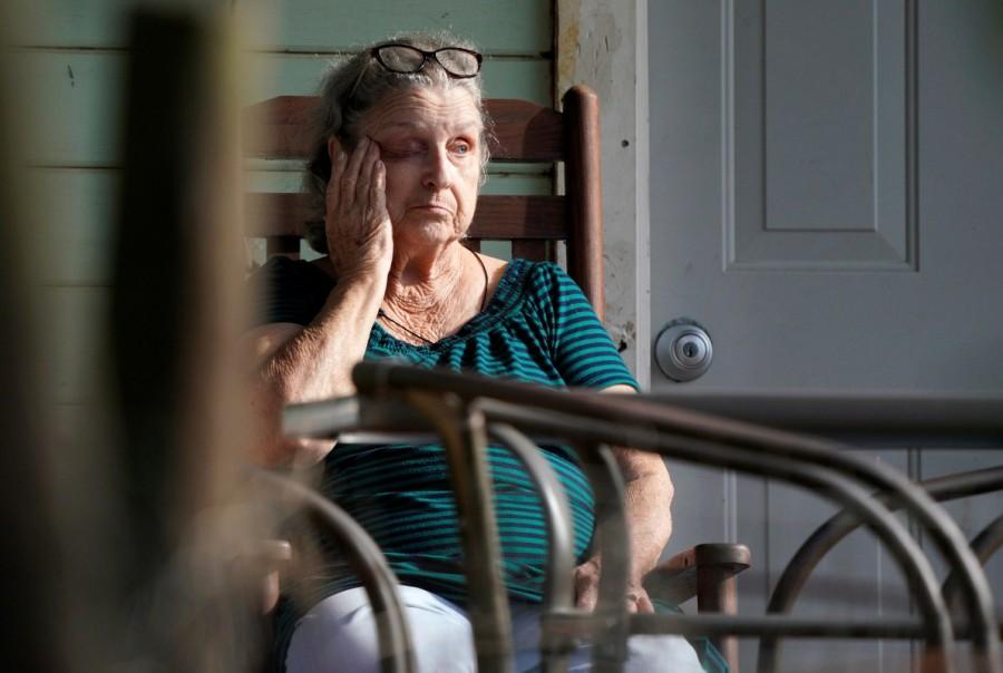 A woman sits on her porch next to the site of a shooting at the First Baptist Church of Sutherland Springs, Texas U.S. November 6, 2017. Mass shooting,Texas church,First Baptist Church,Texas church gunman Devin Kelley,Devin Kelley