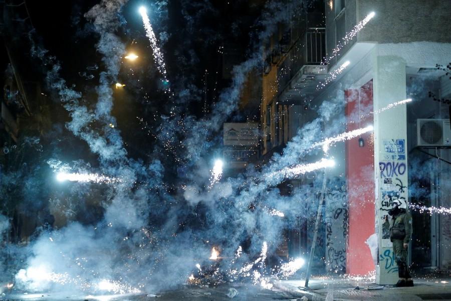 A firework explodes next to a riot policeman during clashes following a rally marking the 44th anniversary of a 1973 student uprising against the military dictatorship that was ruling Greece, in Athens, Greece. Fiery protests,Greece,Greece protests,Protesters clash,Fiery protests in Greece