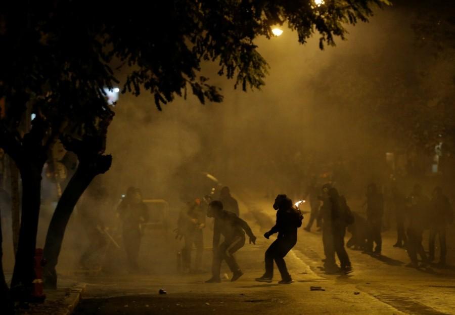 A hooded protester is seen throwing a petrol bomb during clashes following a rally marking the 44th anniversary of a 1973 student uprising against the military dictatorship that was ruling Greece, in Athens, Greece. Fiery protests,Greece,Greece protests,Protesters clash,Fiery protests in Greece
