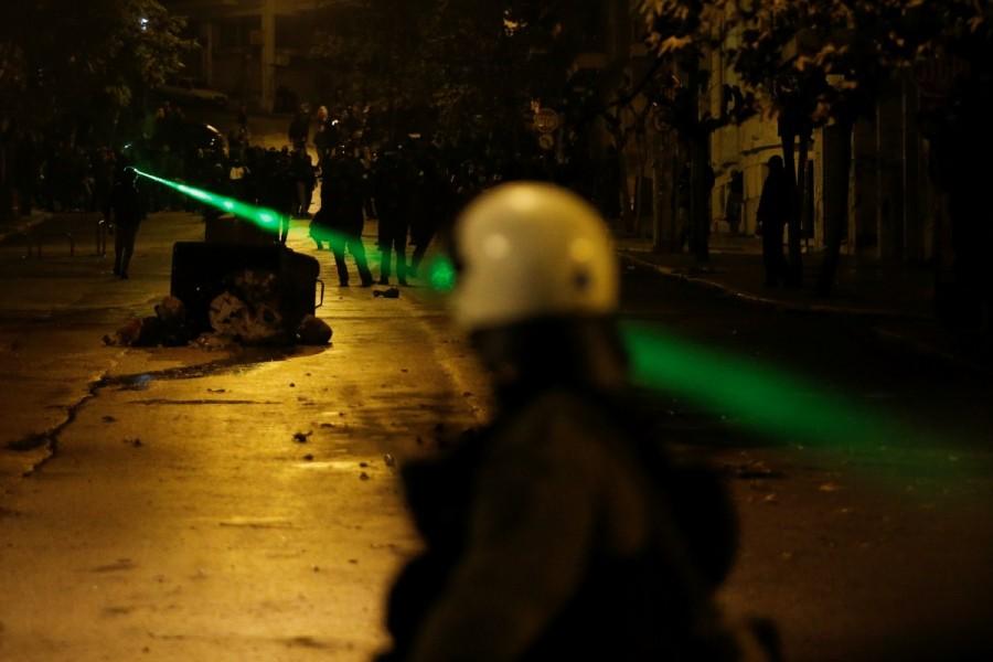 Protesters point a laser at riot police during clashes following a rally marking the 44th anniversary of a 1973 student uprising against the military dictatorship that was ruling Greece, in Athens, Greece. Fiery protests,Greece,Greece protests,Protesters clash,Fiery protests in Greece