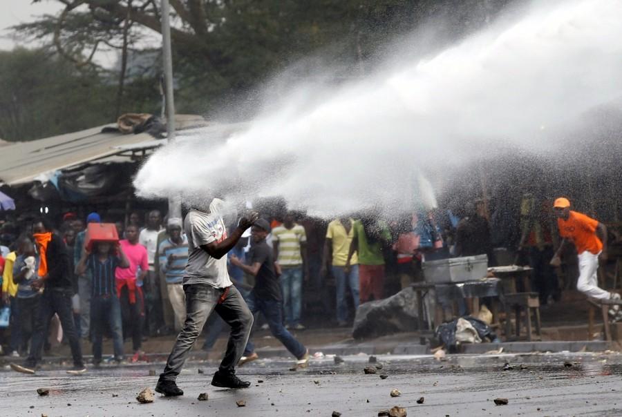 A supporter of Kenyan opposition leader Raila Odinga is sprayed with water by police in Nairobi. Kenya,Kenya as violence,Kenyan opposition leader returns,Raila Odinga,Raila Odinga return