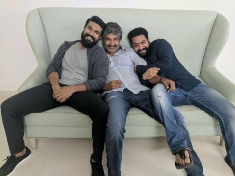 Pic of the day!!! SS Rajamouli is seen seated on a white sofa, with actors Mega Powerstar Ram Charan and Young Tiger Jr NTR sitting on either side of him.