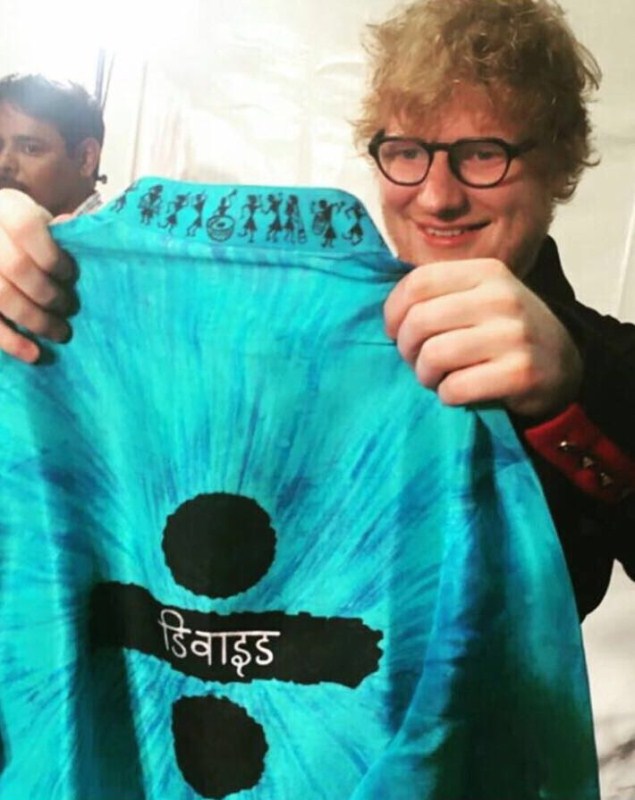 The blue kurta, which Ed Sheeran paired with a comfortable pair of jeans, was inspired by his genre-defying third studio album ÷ (divide) that released earlier this year. It was a part of a specially put together ‘Welcome to India’ hamper by BookASmile which included many hand crafted and personalised goodies that brought Ed Sheeran a little bit closer to the Indian culture. These included a beautiful flute, made to order Ed Sheeran’s favourite gingerbread cookies, Kolhapuri Chappals, a postcard, mug among many other things. Mystery behind Ed Sheeran,Ed Sheeran,Ed Sheeran blue Kurta,Ed Sheeran Kurta