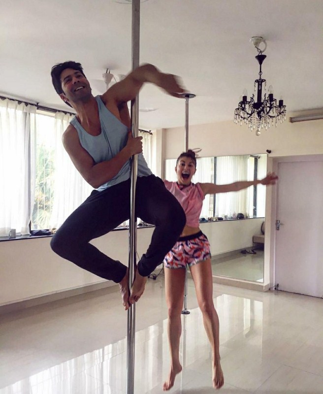 Varun Dhawan recently took to his social media to share an image of himself on a pole, with Jacqueline mentoring him. Varun's captain acknowledges the amount of efforts it takes to do the pole dance. It seems Varun was inspired by Jacqueline to take up the pole dance workout. Judwaa 2,Jacqueline Fernandez,Jacqueline Fernandez and Varun Dhawan,Varun Dhawan,Jacqueline Fernandez Pole Dancing,Varun Dhawan Pole Dancing
