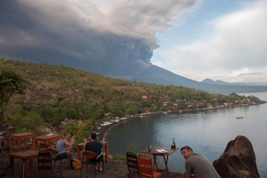 Tourists watch the eruption of Mount Agung at a restaurant on Jemeluk Beach, Amed, Karangasem, Bali, November 26, 2017 in this photo taken by Antara Foto. Mount Agung,Mount Agung volcano,Mount Agung spewing smoke,cracks on Mount Agung,Bali volcano,Bali volcano erupts,Bali volcano eruption