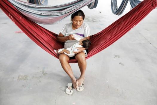 An indigenous Warao woman, from the Orinoco Delta in eastern Venezuela, bottle feeds her baby at a shelter in Pacaraima, Roraima state, Brazil November 15, 2017. An indigenous tribe that journeyed hundreds of kilometers to flee the economic crisis in Venezuela has been trapped in limbo near the border in Brazil, after it was moved off the streets of the Amazon city of Manaus.