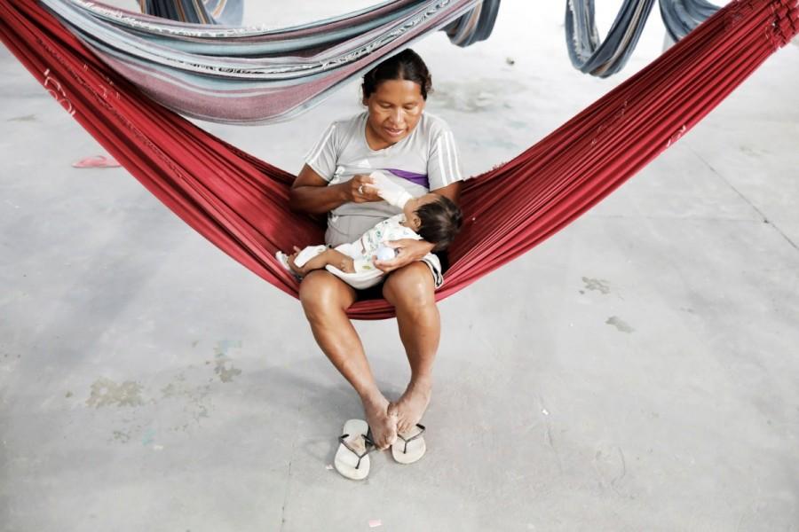 An indigenous Warao woman, from the Orinoco Delta in eastern Venezuela, bottle feeds her baby at a shelter in Pacaraima, Roraima state, Brazil November 15, 2017. An indigenous tribe that journeyed hundreds of kilometers to flee the economic crisis in Venezuela has been trapped in limbo near the border in Brazil, after it was moved off the streets of the Amazon city of Manaus. Venezuela's indigenous,Venezuela indigenous,Venezuela,Orinoco River delta,Warao tribe