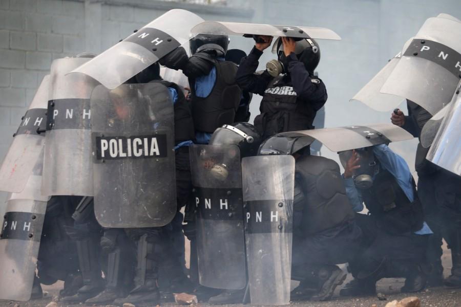 Riot police protect themselves with their shields during a clash with supporters of Salvador Nasralla as they wait for official presidential election results in Tegucigalpa, Honduras, November 30, 2017. Escalating election crisis,Honduran police,Honduras