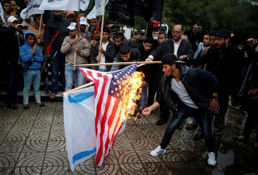Palestinians burn an Israeli and a U.S. flag during a protest against the U.S. intention to move its embassy to Jerusalem and to recognize the city of Jerusalem as the capital of Israel, in Gaza City. Donald Trump,President Donald Trump,Jerusalem decision,Jerusalem,jerusalem violence