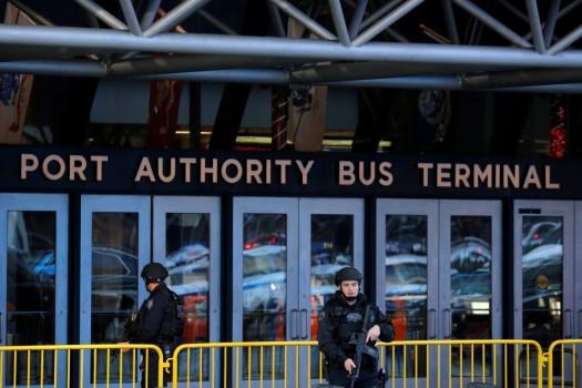 Police officers stand guard outside the New York Port Authority Bus Terminal.
