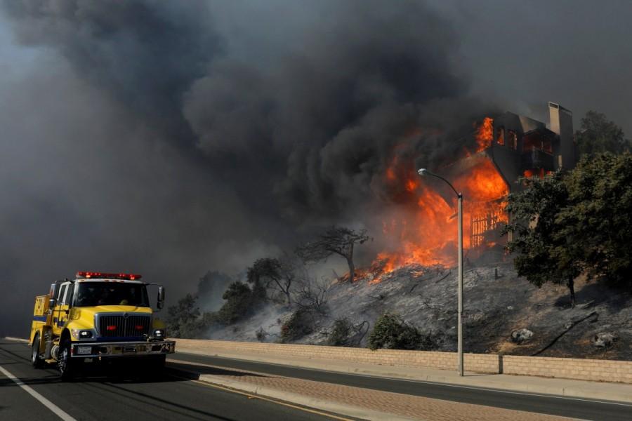 A fire crew passes a burning home during a wind-driven wildfire in Ventura, California, U.S., December 5, 2017. Southern California wildfire,California wildfire,Los Angeles,wildfire,Thousands flee California wildfires
