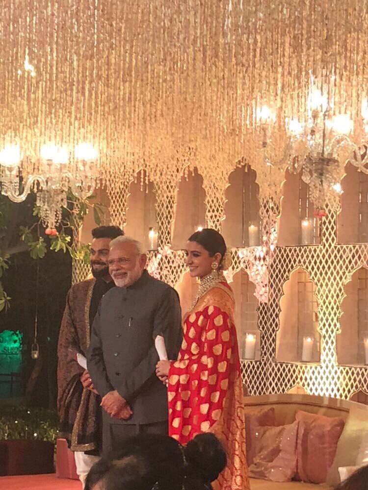 Anushka was all smiles as she looked every bit of the newly married bride donning a red sari. With a neatly-tied bun adorned by a 'gajra', the 'Rab Ne Bana Di Jodi' star completed her looks with heavy jewellery and vermilion. Narendra Modi,PM Narendra Modi,Narendra Modi at Virat Kohli wedding reception,Narendra Modi at Anushka Sharma's wedding reception