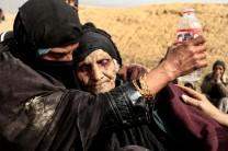 Displaced Iraqi women who just fled their home rest in the desert as they wait to be transported, while Iraqi forces battle with Islamic State militants in western Mosul, Iraq February 27, 2017.