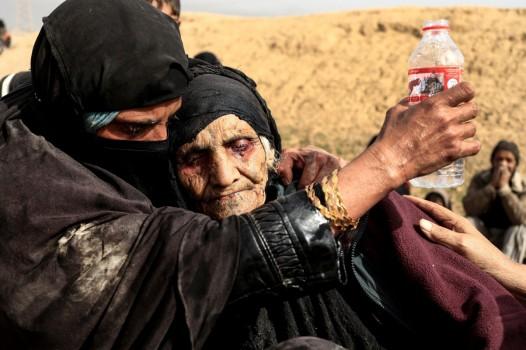 Displaced Iraqi women who just fled their home rest in the desert as they wait to be transported, while Iraqi forces battle with Islamic State militants in western Mosul, Iraq February 27, 2017.