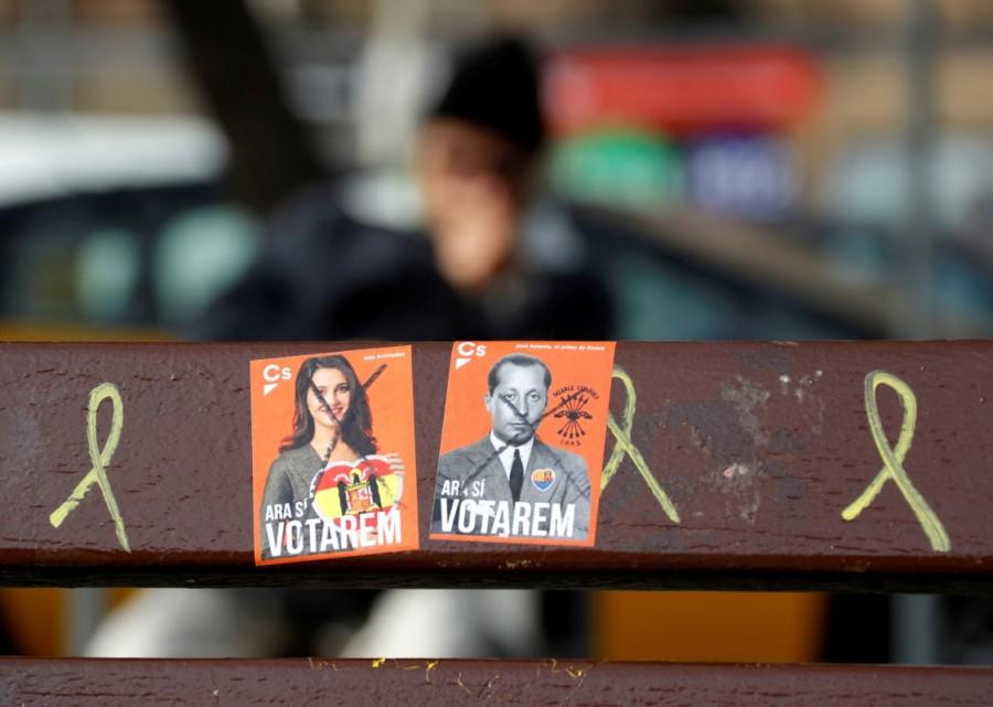 A defaced and a mock Ciudadanos election sticker are seen on a bench graffitied with yellow ribbons, symbolizing the demand for the release of jailed Catalonian politicians, in Barcelona, Spain, December 22, 2017. Catalan separatists win vote,Catalan separatists,Spanish Prime Minister Mariano Rajoy,Mariano Rajoy