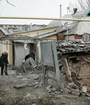 A woman cleans up debris near her house damaged by recent shelling in the rebel-held town of Yasynuvata, Ukraine December 21, 2017.