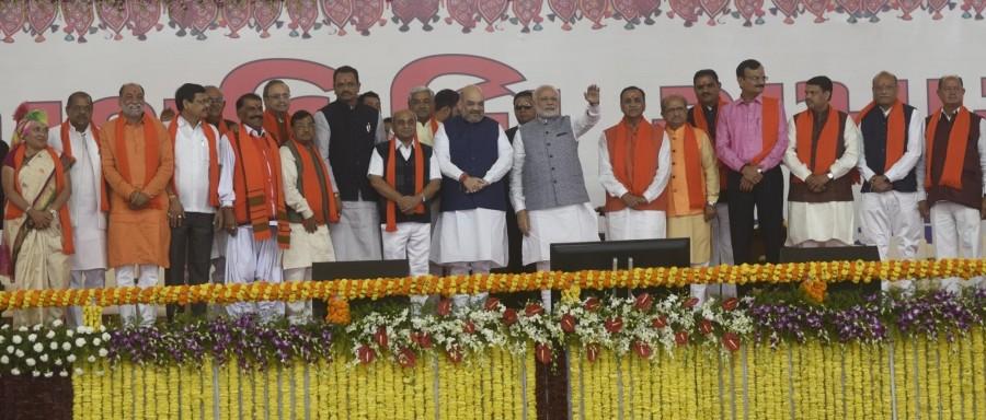 Vijay Rupani on Tuesday took oath as Chief Minister of Gujarat for a second stint along with his deputy Nitin Patel, eight cabinet Ministers and 10 Ministers of State. The new council of ministers was sworn in at a grand ceremony here at the new secretariat helipad ground in the presence of Prime Minister Narendra Modi, Bharatiya Janata Party (BJP) President Amit Shah, Union Ministers Rajnath Singh, Nitin Gadkari, Ram Vilas Paswan, Chief Ministers of the BJP ruled states and Bihar Chief Minister Nitish Kumar. It was also a sea of saffron with a score of spiritual leaders from whom Modi took blessings before the ceremony started. Vijay Rupani,Gujrat CM Vijay Rupani,Vijay Rupani takes oath