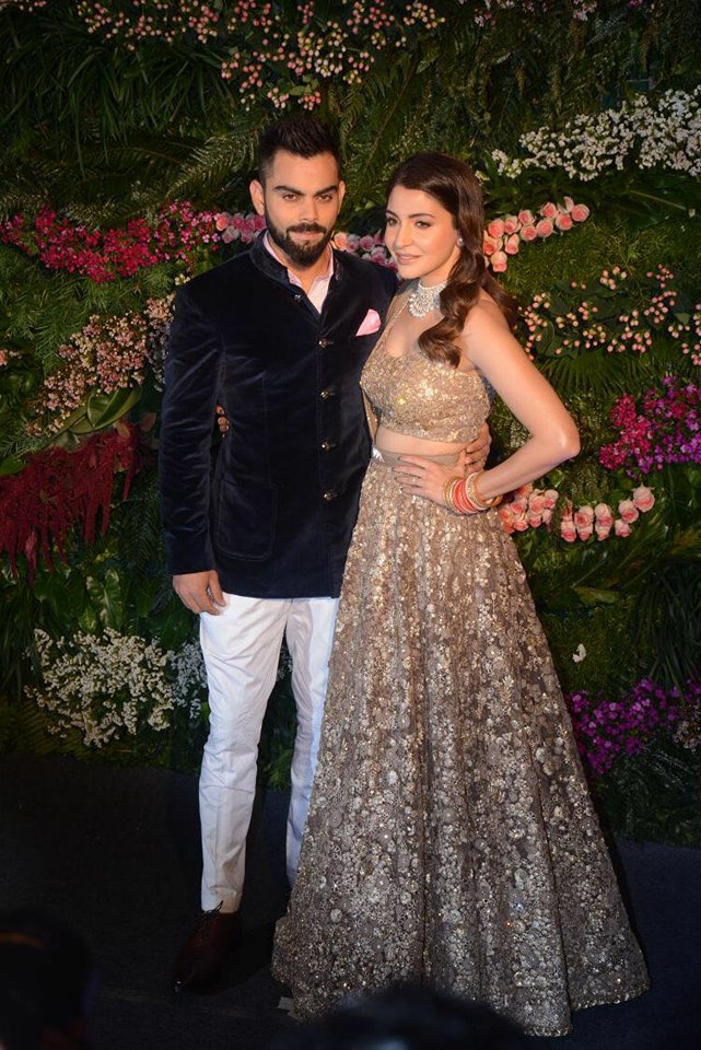 The couple looked beautiful. While Anushka seen in side slick hair with cascading curls and nude lips to go with the elegant vibe of her ensemble and wearing a Sabyasachi creation - a dull gold heavily embroidered and embellished lehenga set teamed with a matching dupatta, cinched at the waist with a signature Sabyasachi belt. She completed the heavy dress with simple earing studs, a diamond neck-piece and traditional Punjabi red bangles set. Virat Kohli and Anushka Sharma,Virat Kohli and Anushka Sharma Mumbai reception,Virat Kohli and Anushka Sharma Mumbai reception pics,Virat Kohli and Anushka Sharma Mumbai reception images,Virat Kohli,Anushka Sharma