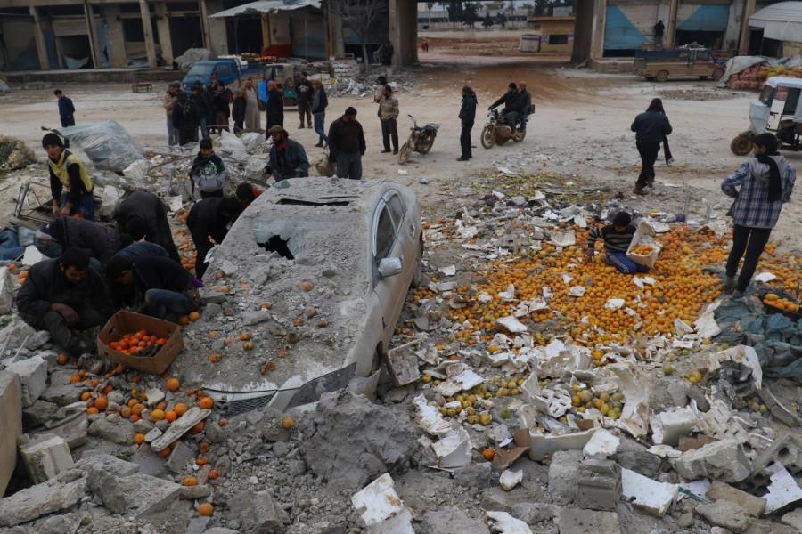 People collect scattered oranges amidst rubble after an airstrike on a market in rebel held Maarrat Misrin city in Idlib province, Syria January 14, 2017. Best pictures,Best pictures 2017,2017 Best pictures,2017 top pictures,2017 top pics,2017 top images,2017 top stills,2017 top photos