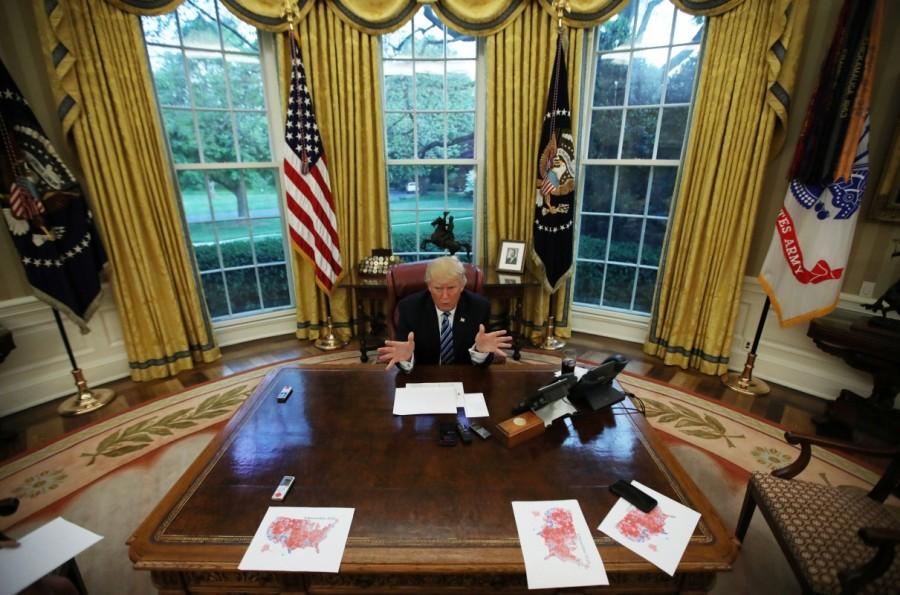 U.S. President Donald Trump speaks during an interview with Reuters in the Oval Office of the White House in Washington, U.S., April 27, 2017. Carlos Barria: "A day before President Trump's hundred days in office I was part of the team that interviewed the commander-in-chief in the Oval Office. I was only allowed to photograph Trump during the last five minutes of the interview. The time was very tight so I had to move fast as I had pictures in mind that I wanted to shoot. I walked into the Oval Office and saw that the President had printed maps of the country showing areas in red where he won. I raised my hands holding my camera as high as possible to get the best view of the scene using a 16mm wide angle lens." President Donald Trump,Donald Trump,US President Donald Trump,Donald Trump viral moments