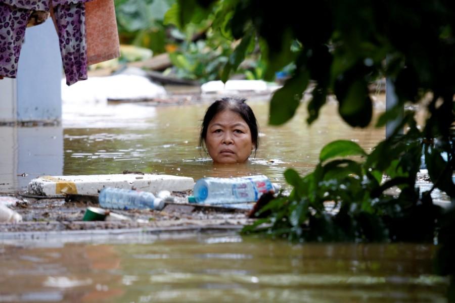 A woman wades through a submerged street in the UNESCO heritage ancient town of Hoi An after typhoon Damrey hit Vietnam, November 6, 2017. Natural disasters of 2017,disasters in 2017,2017 natural disasters,2017 disasters