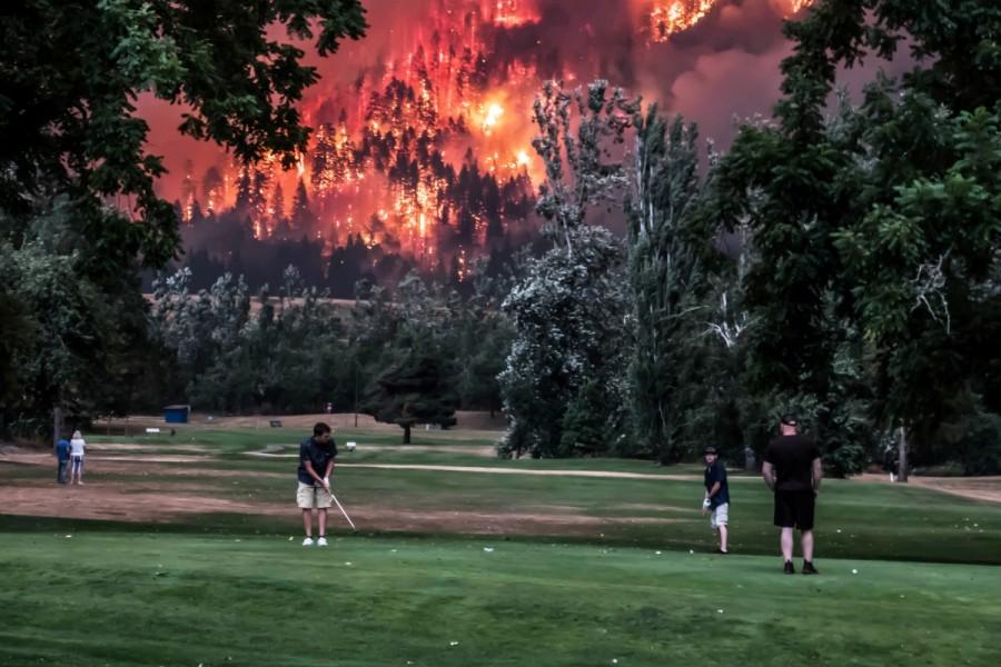The Eagle Creek wildfire burns as golfers play at the Beacon Rock Golf Course in North Bonneville, Washington, U.S. September 4, 2017. Natural disasters of 2017,disasters in 2017,2017 natural disasters,2017 disasters