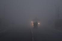 People cross a road in front of a truck in heavy fog in Belfast, Northern Ireland, January 10, 2018.