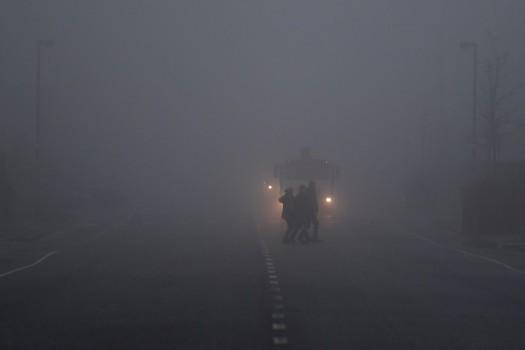 People cross a road in front of a truck in heavy fog in Belfast, Northern Ireland, January 10, 2018.