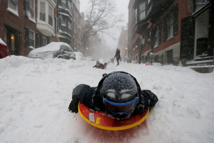 A boy sleds down a Beacon Hill street during Storm Grayson in Boston, Massachusetts, U.S., January 4, 2018. U.S. Northeast,Blizzard roars,Blizzard roars in US