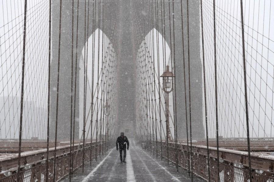 A pedestrian walks through blinding snow across the Brooklyn Bridge during Storm Grayson in New York City, U.S., January 4, 2018. U.S. Northeast,Blizzard roars,Blizzard roars in US