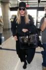 Reality star Khloe Kardashian hides her growing baby bump at the Los Angeles International Airport.