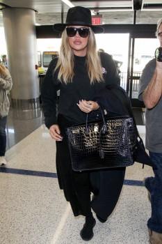 Reality star Khloe Kardashian hides her growing baby bump at the Los Angeles International Airport.