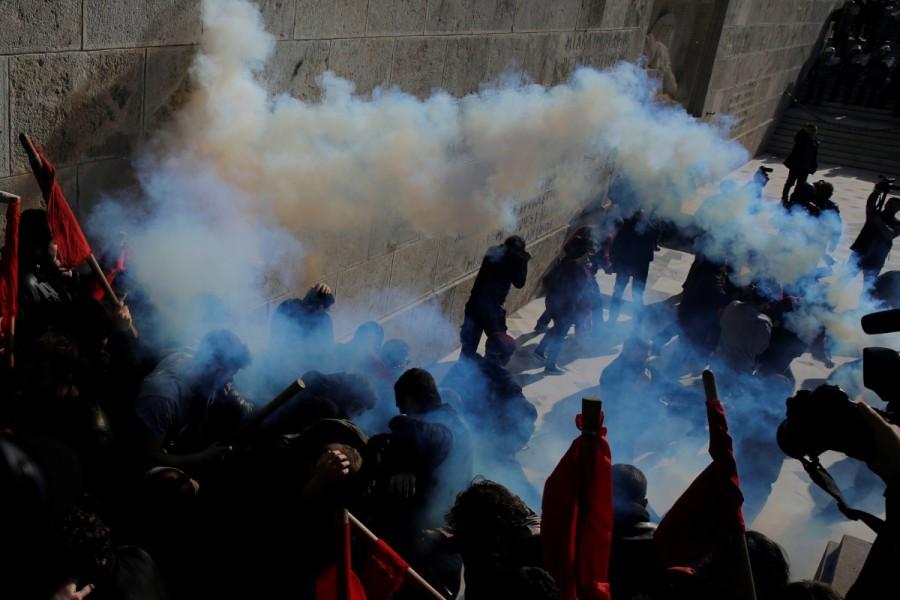 Protesters flee tear gas as they clash with riot police during a demonstration outside the parliament building against planned government reforms in Athens. Protests and clashes,Protests in Athens,clashes in Athens,Athens parliament