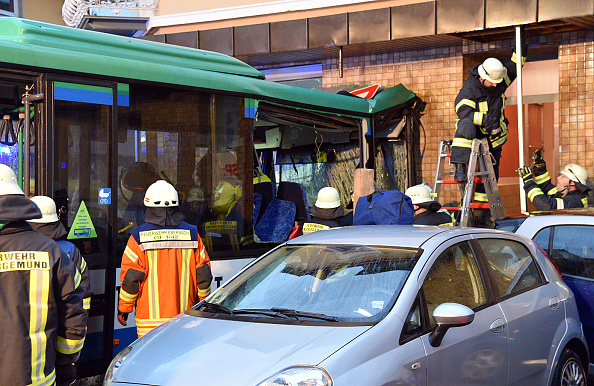 Police and firefighters secure the area around a schoolbus that crashed into a shop on early January 16, 2018 in the southern German town of Eberbach, near Heideleberg. Germany school bus crash,Germany school bus,school bus crash,school bus accident